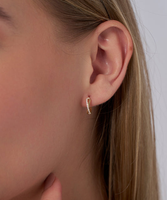 Model wearing Pave Diamond Twist Huggie Hoops