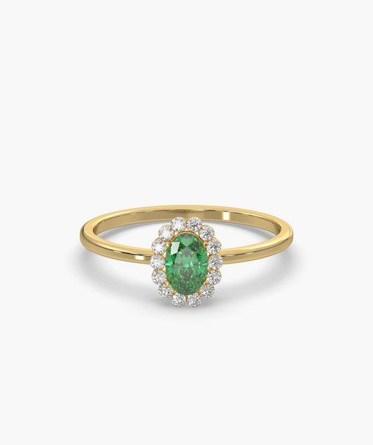 Gold ring with a green gemstone and diamond accents on a white background