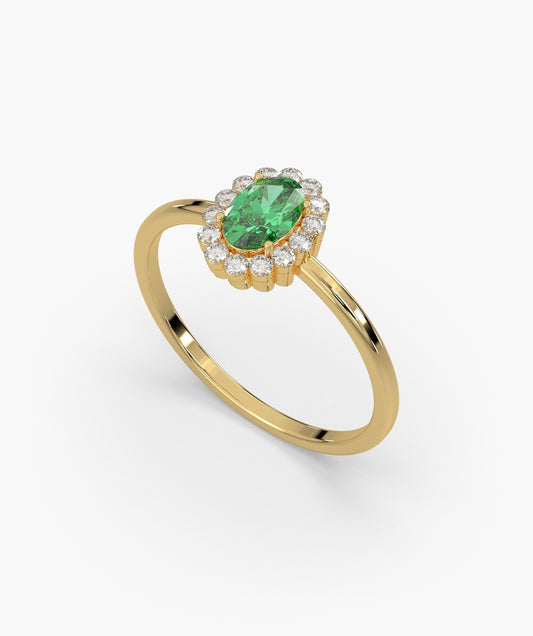Gold ring with a green gemstone and diamond accents on a white background
