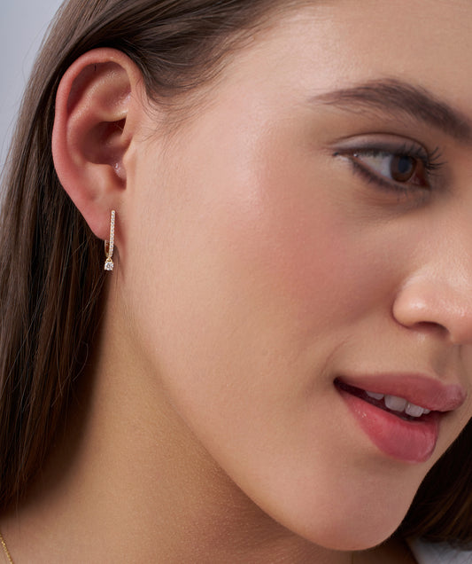 Model Wearing Pavé Diamond Huggie Hoops with Solitaire Drop