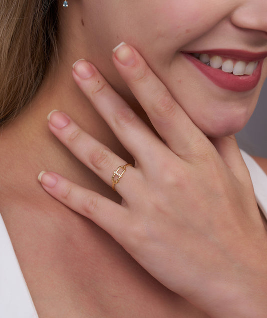 Close-up of a woman's hand wearing a gold ring with a blurred background